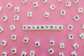 Chlamydia word made of square letter word on pink background.