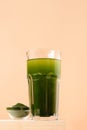 Chlorella Detox drink in glass on beige background. Vertical.