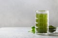 Chlorella healthy beverage in glass on a grey background.