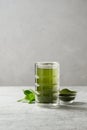 Chlorella healthy beverage in glass on a grey background.