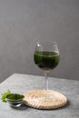 Chlorella healthy beverage in glass on a grey background