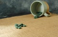 Chlorella or spirulina tablets falling out of mug Royalty Free Stock Photo