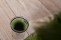 Chlorophyll extract is poured into clean water in a glass on a wooden background with a green leaf. Liquid chlorophyll in a glass Royalty Free Stock Photo