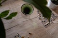 Chlorophyll extract is poured into clean water in a glass on a wooden background with a green leaf. Liquid chlorophyll in a glass Royalty Free Stock Photo