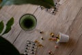 Chlorophyll extract is poured into clean water in a glass on a wooden background with a green leaf. Liquid chlorophyll in a glass Royalty Free Stock Photo