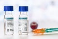 Chloroquine phosphate generic name drug in small injection bottles with blue caps, orange green syringe near own label design