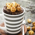 Chocolate aromatic mug cake with caramel appetizing popcorn for autumn cozy warm tea drinking on a gray stone background Royalty Free Stock Photo