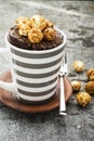 Chocolate aromatic mug cake with caramel appetizing popcorn for autumn cozy warm tea drinking on a gray stone background Royalty Free Stock Photo