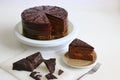 Chocolate Austrian cake sacher sliced on white table background. Sacher cake slice. Traditional Austrian chocolate dessert.