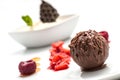 Chocolate ball with ice cream and fruit on white plate, sweet dessert with chocolate, product photography for patisserie or restau