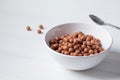 Chocolate balls corn flakes in white bowl, white background. Breakfast food concept Royalty Free Stock Photo