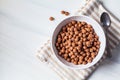 Chocolate balls corn flakes in white bowl, white background. Breakfast food concept Royalty Free Stock Photo