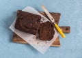 Chocolate banana bread on a rustic cutting board on blue background. Royalty Free Stock Photo