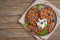 Chocolate banana waffles with blueberries, on dark wooden old table. Top view, copy space Royalty Free Stock Photo