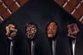 Chocolate bar, cocoa powder, cacao beans and nibs, heap in wooden spoons, chocolate background Royalty Free Stock Photo