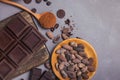 Chocolate bar and drops, cocoa beans and powder on grey background Royalty Free Stock Photo