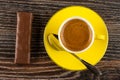 Chocolate bar with filling, cup with black coffee, spoon on saucer on wooden table. Top view Royalty Free Stock Photo