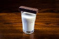 Chocolate bar on a glass of milk on a wooden background close up Royalty Free Stock Photo