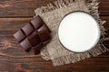 Chocolate bar and glass of milk on wooden. Royalty Free Stock Photo