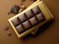 Chocolate bar with a gold wrapper sits on a table with a some coffee beans Royalty Free Stock Photo