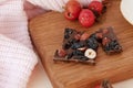 Chocolate bar with hazelnuts and raisins on wooden board