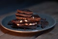 chocolate bar with peanuts on gray plate on brown background Royalty Free Stock Photo