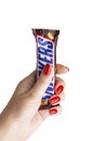 Chocolate bar Snickers to a female hand.