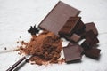 Chocolate bar and spice on table background / chocolate pieces chunks powder on spoon candy sweet dessert for snack