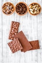 Chocolate bars of different varietes on grey wooden background top view