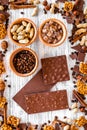 Chocolate bars of different varietes on grey wooden background top view