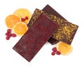 Chocolate bars with freeze dried fruits, raspberries and orange slices on white background, top view Royalty Free Stock Photo