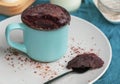 Chocolate biscuit cake in a blue ceramic mug, microwave baking. muffin