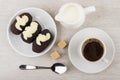 Chocolate biscuit cakes with buttercream in saucer, jug milk, co Royalty Free Stock Photo