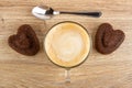 Chocolate biscuits in form of heart, spoon, cappuccino in cup on table. Top view Royalty Free Stock Photo