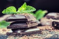 Chocolate. Black chocolate. A few cubes of black chocolate with mint leaves.