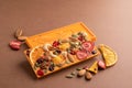 Chocolate bright orange whole tile with fruit nuts brown background. Dessert food concept. Horizontal frame copy space