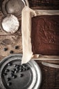 Chocolate brownie on the baking tray with blueberry and plates vertical