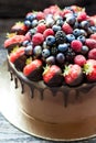 Chocolate brownie cake with fresh summer berries. Decorated with strawberries dipped into melted chocolate. Royalty Free Stock Photo