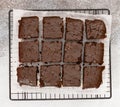 Chocolate brownie cakes on baking rack on grey stone background.