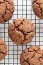 Chocolate brownie cookies with crack on cooling rack on white background. Homemade crinkle cookies