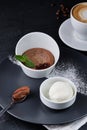 Chocolate brownie and ice cream on a dark grey plate next to a cup of coffee. Royalty Free Stock Photo