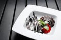 Chocolate brownie with ice cream and strawberries on a black wooden Royalty Free Stock Photo