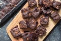Chocolate brownie squares taken out of baking tin and place on wooden board - overhead photo brownies with melted chocolate bits