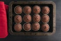 Chocolate brownies muffins on baking sheet and red pot-holders on black background. Just cooked homemade cupcake Royalty Free Stock Photo