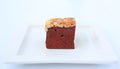 Chocolate brownies on white square plate, Brownie cake topped with nuts