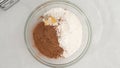 Chocolate buttercream icing preparation process. Mixing ingredients in glass bowl