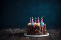 Chocolate cake with candles on a dark blurred background