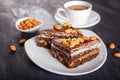 Chocolate cake with caramel, peanuts and almonds on a black wooden background Royalty Free Stock Photo