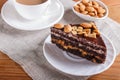 Chocolate cake with caramel, peanuts and almonds on a brown wooden background Royalty Free Stock Photo