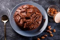 Chocolate cake with chocolate pieces on a metallic black background